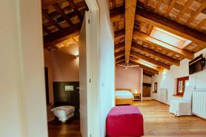 a bedroom with a bed and a toilet in a room at Agriturismo Ronchi Rò in Lonzano