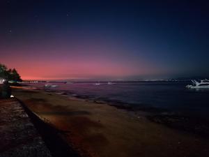 ein Strand in der Nacht mit Booten im Wasser in der Unterkunft Bagus Cottage in Nusa Penida