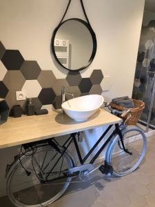 een badkamer met een fiets en een spiegel bij Chambres d`hôtes Domaine des Haies in Dol-de-Bretagne