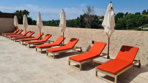 a row of red chairs and white umbrellas at Villa Martinus in Saint Paul de Vence