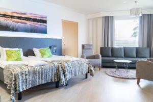 ein Hotelzimmer mit 2 Betten und einem Sofa in der Unterkunft Spa Hotel Kunnonpaikka in Kuopio
