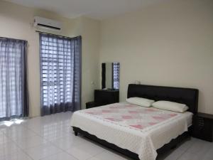 ein Schlafzimmer mit einem Bett und zwei Fenstern in der Unterkunft Fong's Ipoh SImpang Pulai Homestay in Ipoh