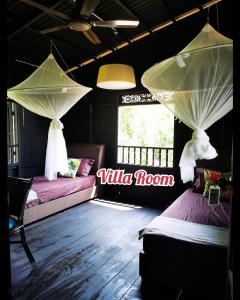 a room with two beds and a sign that reads willrina room at Harrera Perhentian, Long Beach in Perhentian Island