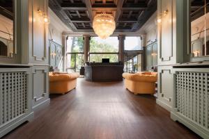 a large lobby with orange chairs and a stage at Mokinba Hotels Montebianco in Milan