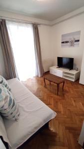 a bedroom with a bed and a tv and a table at Apartmani Karmen Mali Maj in Poreč