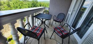 a balcony with four chairs and a table on a porch at Villa Karla in Jadranovo