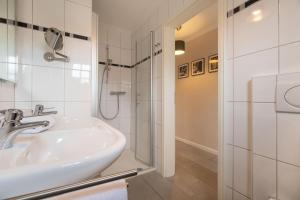 a bathroom with a sink and a shower at Ferienwohnung Seeschwalbe in Südstrand +16 photos