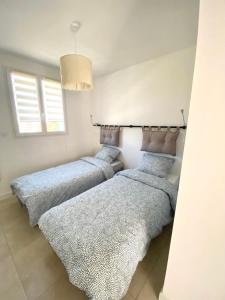 duas camas num quarto com duas janelas em Casa di Marina em Santa-Lucia-di-Moriani