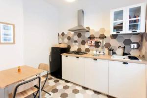 a kitchen with white cabinets and a black refrigerator at Bellissimo Appartamento a Perugia in Perugia