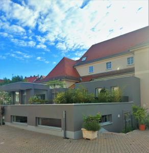 une maison avec un toit rouge et quelques plantes dans l'établissement Hotel PrimaVera parco, à Fürth