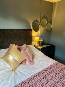 Un dormitorio con una cama con una manta rosa y espejos en Coastal Cabin Chalet, en Roch