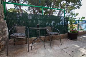 einen Tisch und zwei Stühle neben einem Zaun in der Unterkunft Old Town Accommodation in Bol