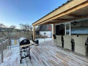 a large deck with a grill and chairs on it at Totina Apartments in Závažná Poruba