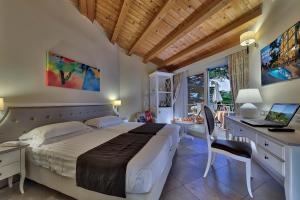 een slaapkamer met een bed en een bureau met een laptop bij Hotel Excelsior Le Terrazze in Garda