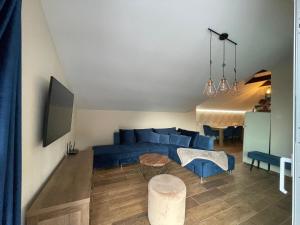 a living room with a blue couch and a table at Totina Apartments in Závažná Poruba