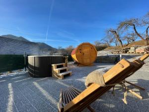 a wooden bench and a wooden barrel and a wooden tent at Totina Apartments in Závažná Poruba