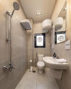 a bathroom with a toilet and a sink and a shower at Travelholic Residence Golden Gates in Cairo