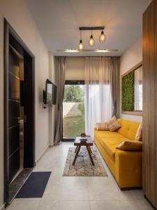 a living room with a yellow couch and a tv at Travelholic Residence Golden Gates in Cairo