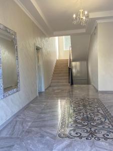 an empty hallway with a tile floor and a chandelier at KEMO house in Batumi