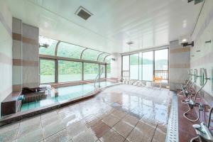 JozankeiMolinHotels602 アクティビティを満喫できる札幌定山渓 天然温泉付- 1L2Room S-Bed8 8Persons的大型浴室设有窗户和游泳池
