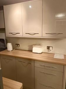 a kitchen with a counter with a telephone and cabinets at Coastal Cabin Chalet in Roch