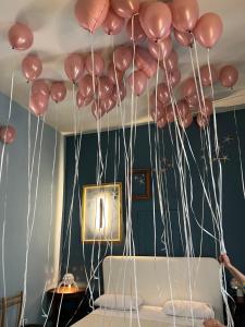 Um monte de balões cor-de-rosa pendurados no tecto. em Suites Edivino Design Capri em Capri