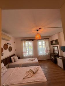1 dormitorio con 2 camas y lámpara de araña en Mor Salkım Konağı, en Alacati