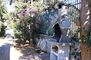 einen Steinofen auf einer Bank neben einem Zaun in der Unterkunft Mondello Holiday Home in Mondello