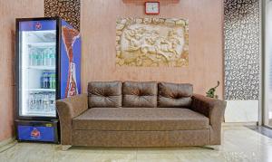 um sofá castanho num quarto com um frigorífico em Treebo Trend Amber Imperial em Mumbai