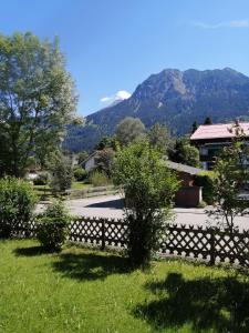 einen Zaun in einem Hof mit Bergen im Hintergrund in der Unterkunft Ferienwohnung Rubihornblick in Oberstdorf