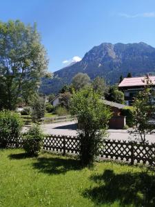 une clôture dans une cour avec des montagnes en arrière-plan dans l'établissement Ferienwohnung Rubihornblick, à Oberstdorf