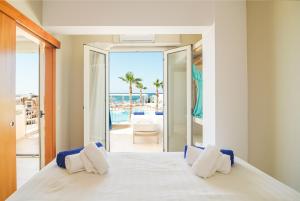 a hotel room with two beds and two windows at Parthenis Beach, Suites by the Sea in Malia