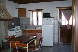 a kitchen with a table and a white refrigerator at petit gite in Rilly-sur-Loire