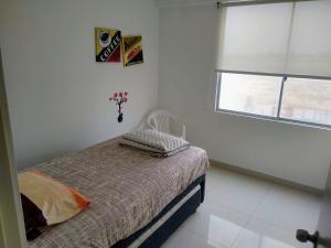 - une chambre blanche avec un lit et une fenêtre dans l'établissement Departamento en Punta Hermosa con Vista al Mar, à Punta Hermosa