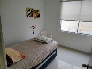 biała sypialnia z łóżkiem i oknem w obiekcie Departamento en Punta Hermosa con Vista al Mar w mieście Punta Hermosa