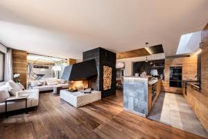 a kitchen and living room with a fireplace in a house at Cocoon Deluxe - Luxury Chalet in Chamois