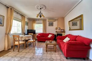 a living room with red couches and a table at Espanhouse Villa in Ciudad Quesada for 4 in Ciudad Quesada