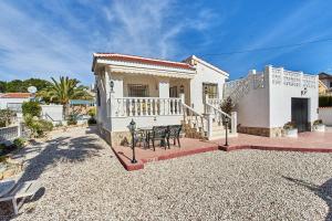 a white house with a table on a patio at Espanhouse Villa in Ciudad Quesada for 4 in Ciudad Quesada
