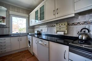 a kitchen with white cabinets and a sink at Espanhouse Villa in Ciudad Quesada for 4 in Ciudad Quesada