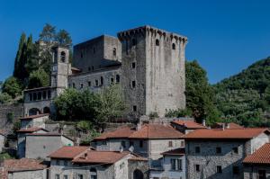 un vieux château au sommet d'une colline avec des maisons dans l'établissement Albergo diffuso "Centoborghi", à Fivizzano