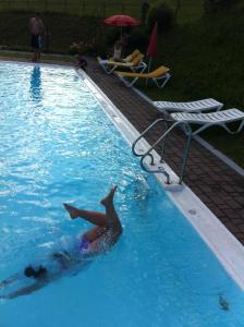 eine Person schwimmt in einem Pool in der Unterkunft Landhaus St. Georg in Saalbach-Hinterglemm
