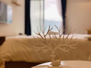 a small tree on a table in front of a bed at TMS Pullman Quy Nhơn in Quy Nhon