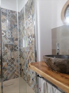 a bathroom with a stone sink and a shower at "la casa dell'architetto" con terrazza panoramica in centro storico e a due passi dal porto in Lipari