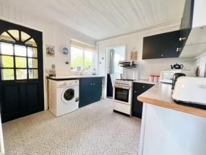 a large kitchen with a washer and dryer in it at 2 bedroom chalet bungalow on Humberston Fitties. in Humberston