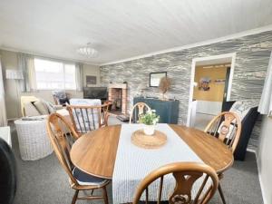a living room with a table and chairs and a fireplace at 2 bedroom chalet bungalow on Humberston Fitties. in Humberston