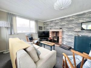 a living room with a couch and a fireplace at 2 bedroom chalet bungalow on Humberston Fitties. in Humberston