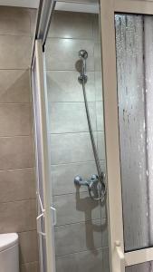 una doccia con porta in vetro in bagno di Appartement de luxe avec piscine a 5 min de la plage a Martil