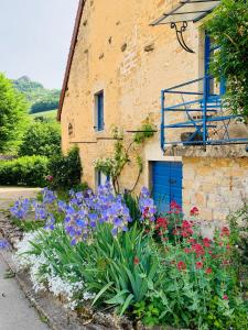 Grusse的住宿－Gîte La Source，一座建筑前的鲜花花园