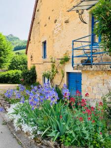 um jardim de flores em frente a um edifício em Gîte La Source em Grusse