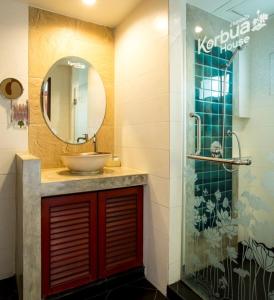 La salle de bains est pourvue d'un lavabo et d'un miroir. dans l'établissement Korbua House, à Bangkok